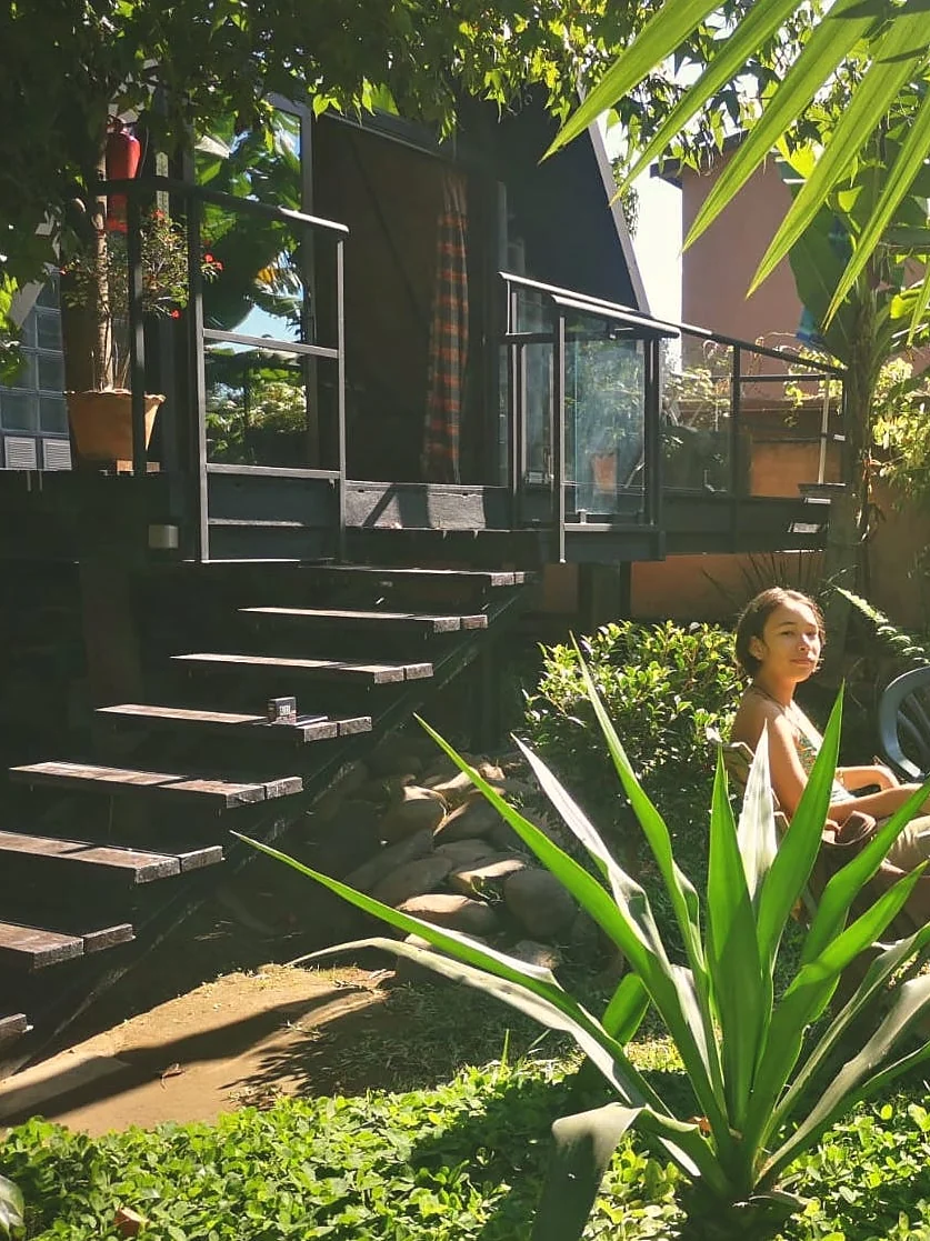 A guest relaxing by the wooden steps in the garden of the B&B