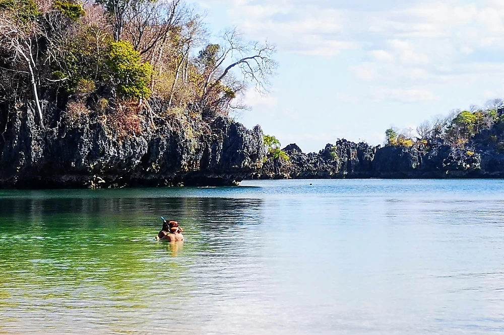 A traveller snorkels in the turquoise water of Moramba Bay, between limestone islets