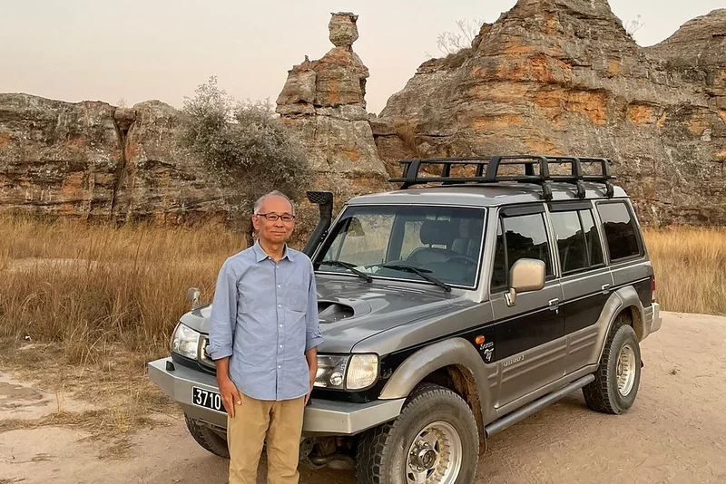 A traveller with his Hyundai Galloper below the sandstone rocks of Isalo