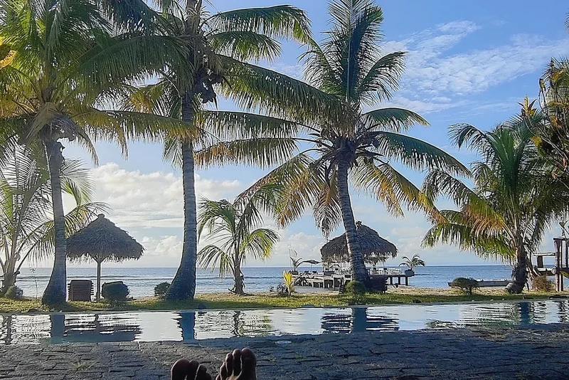 Palm trees, a pool and a wooden jetty on the beach of Île Sainte-Marie